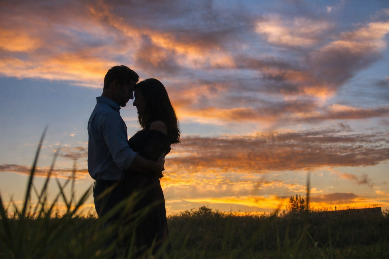 Couple en silhouette au coucher du soleil, moment de connexion émotionnelle
