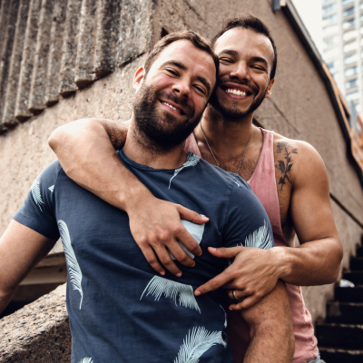 Couple d’hommes souriants et complices illustrant une belle rencontre gay et l’espoir de trouver l’a